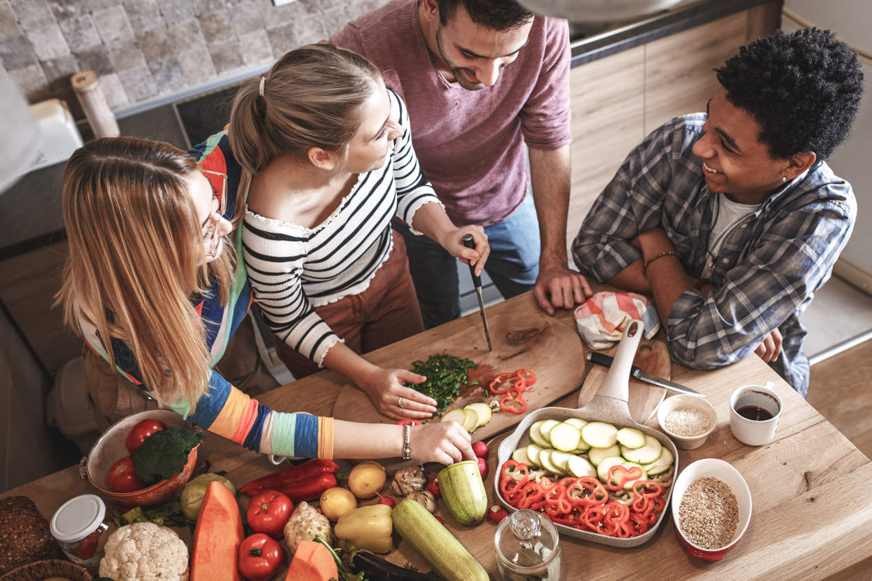 Junge Erwachsene kochen gemeinsam.