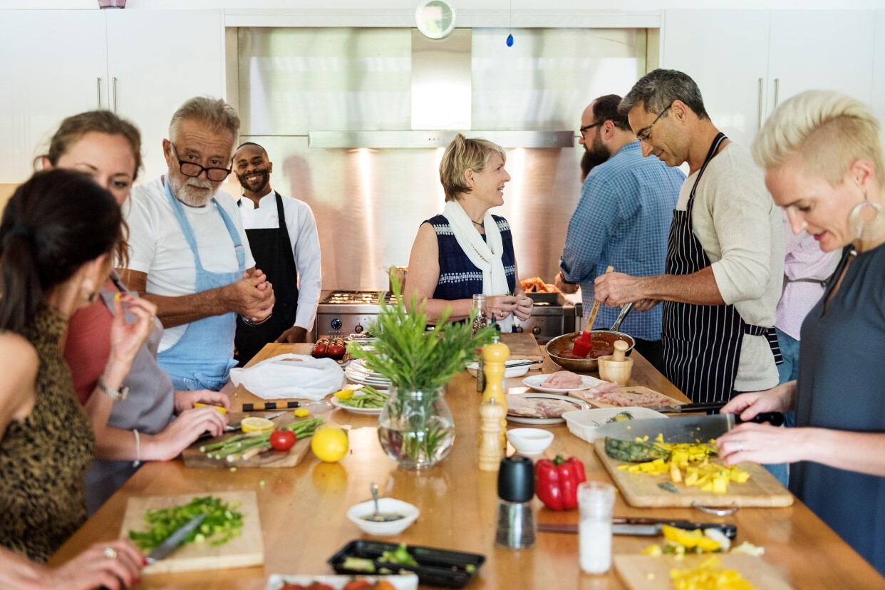 Erwachsene kochen gemeinsam in einer Küche.