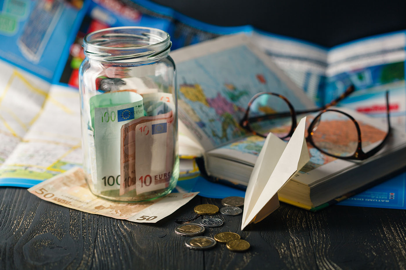 Glas mit Geld, das für Urlaub gespart wird